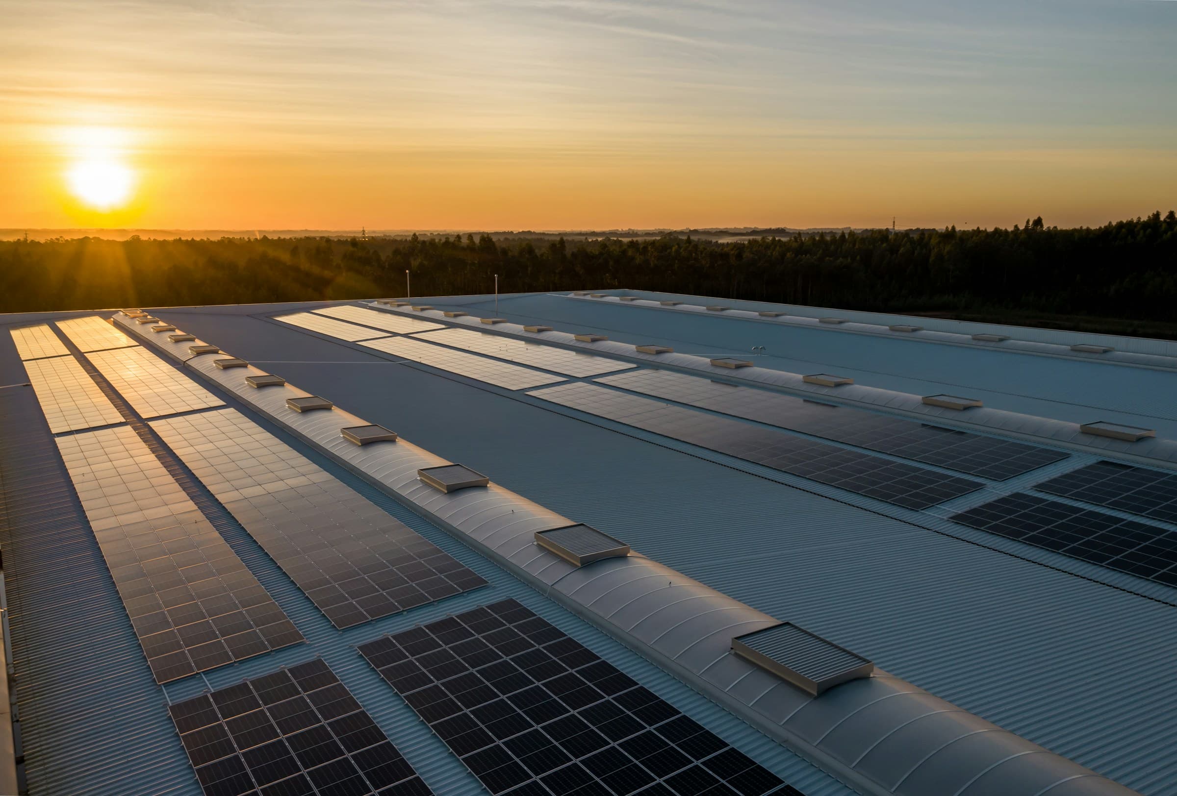 Decorative picture with solar panels on a roof during sunset.