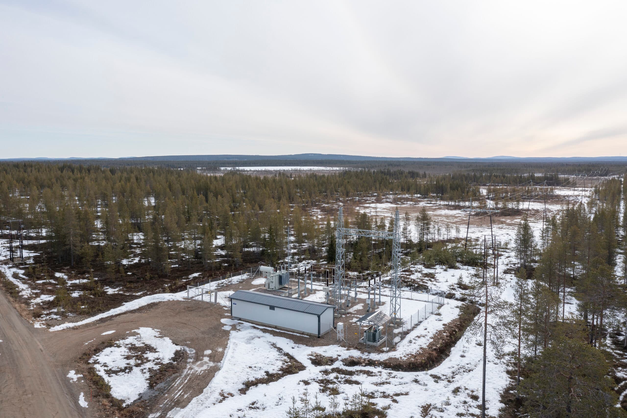 Sähköasema ja osittain lumista metsämaastoa